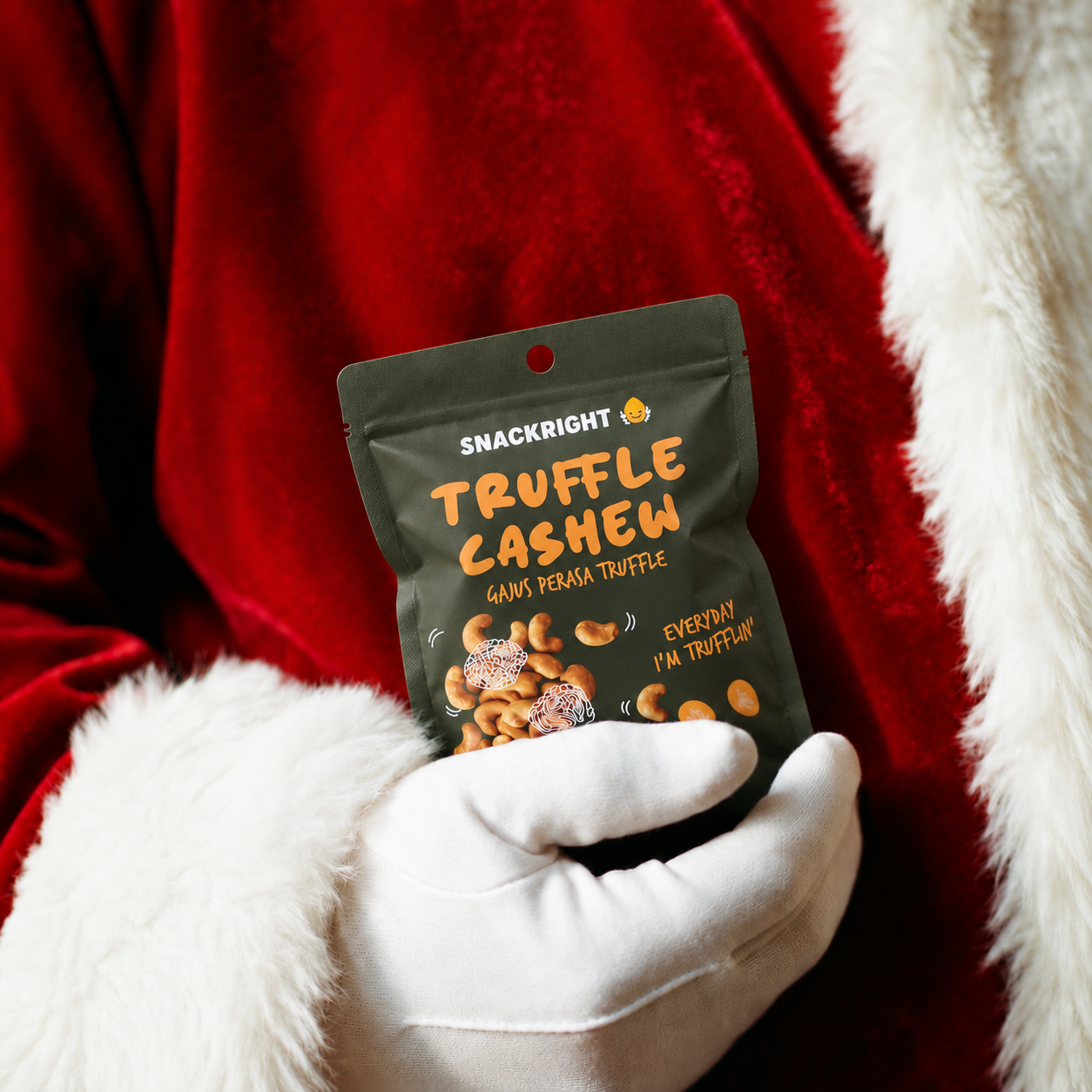Santa holding a matte SnackRight Truffle Cashew pouch